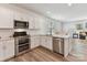 Modern kitchen featuring stainless steel appliances, white cabinets, and an eat-in dining area at 2343 Mt. Harmony Church Rd, Matthews, NC 28104