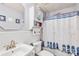 Nautical themed bathroom featuring coastal decor, a vanity sink, toilet, and bathtub with a shower curtain at 256 Rose St, Mooresville, NC 28117