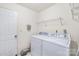 Bright laundry room featuring a white washer and dryer, storage shelves, and a clean, functional space at 256 Rose St, Mooresville, NC 28117