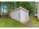 Exterior shot of a white outbuilding in a backyard setting, providing extra storage or workshop space at 256 Rose St, Mooresville, NC 28117