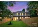 A beautifully manicured backyard surrounded by a wood fence, with a two-story house at dusk at 2723 Capitol Dr, Charlotte, NC 28208