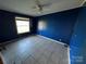 Bedroom with blue walls, tile floor, a window, and ceiling fan at 302 Edwards Rd, Mooresville, NC 28115