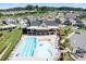 Aerial view showcasing a community pool, playground, clubhouse, and well-maintained neighborhood streets at 3038 Burnello Ct, Iron Station, NC 28080