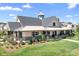 Beautiful clubhouse featuring stone accents, a metal roof, manicured landscaping, and a charming weather vane at 3038 Burnello Ct, Iron Station, NC 28080