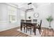 Dining room featuring a modern chandelier, dark wood table and chair set, and plenty of natural light at 3038 Burnello Ct, Iron Station, NC 28080