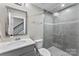 Modern bathroom with gray tiles, a glass-enclosed shower, and a sleek vanity at 318 N Dotger Ave, Charlotte, NC 28204