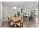 Inviting dining area with a wooden table, seating for six, and a view into the modern kitchen and living spaces at 318 N Dotger Ave, Charlotte, NC 28204