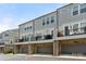 Townhome complex showcasing brick accents, gray siding, dark gray garage doors, and second story outdoor decks at 318 N Dotger Ave, Charlotte, NC 28204