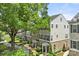 Exterior of multi-story townhomes with brick and gray siding, landscaping, and a sidewalk at 318 N Dotger Ave, Charlotte, NC 28204