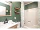 Well-maintained bathroom featuring a shower with a patterned curtain and wooden shelves at 3604 Golfview Dr, Gastonia, NC 28056