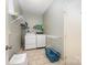 Efficient laundry room with washer, dryer, shelving, and blue laundry basket at 3810 Yorkford Dr, Charlotte, NC 28269
