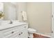 Well-lit half bathroom with white cabinets, and a clean, modern toilet at 4263 Melrose Club Dr, Matthews, NC 28105