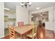 Inviting dining room features hardwood floors, neutral walls, and a wooden table with colorful chairs at 4263 Melrose Club Dr, Matthews, NC 28105