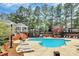 Community pool area with lounge chairs surrounded by brick walls and tall trees at 4263 Melrose Club Dr, Matthews, NC 28105