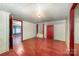 This bedroom has whitewashed walls and red floors with a view into another room through a red door at 4612 Rehobeth Rd, Waxhaw, NC 28173