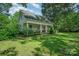 Quaint single-story home with a covered front porch, brick foundation, and lush greenery in a serene setting at 4612 Rehobeth Rd, Waxhaw, NC 28173