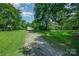 Spacious property showcasing a traditional home with a long gravel driveway, mature trees, and outbuildings at 4612 Rehobeth Rd, Waxhaw, NC 28173