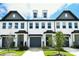 Stylish townhome featuring a painted brick facade, multiple windows, and a well-manicured lawn at 4714 Blanchard Way, Charlotte, NC 28226