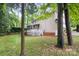 Spacious backyard with mature trees, lawn, fence, and the exterior of a house with a screened-in porch at 4808 Cobble Glen Way, Charlotte, NC 28269