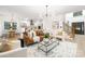 Open concept living room with hardwood floors, modern lighting, and a view into the kitchen and dining area at 4808 Cobble Glen Way, Charlotte, NC 28269