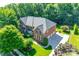 Aerial view of a brick home with a three-car garage and lush, green surroundings at 5008 Woodview Ln, Weddington, NC 28104