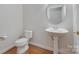 Clean, well-maintained bathroom features a pedestal sink, toilet, and hardwood flooring at 5008 Woodview Ln, Weddington, NC 28104