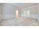 Expansive living room featuring patterned carpet, wainscoting and natural light throughout at 5008 Woodview Ln, Weddington, NC 28104