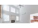 High ceiling living room with fireplace, large windows, and a view of the kitchen at 5008 Woodview Ln, Weddington, NC 28104