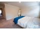A carpeted bedroom with a full-size bed, a floor mirror and an open doorway at 508 Tayberry Ln, Fort Mill, SC 29715
