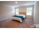 A bright bedroom with neutral carpet, a queen bed with a blue throw, and windows with blinds at 508 Tayberry Ln, Fort Mill, SC 29715