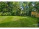 A spacious backyard with a lush lawn and a wooden deck at 5175 Grand Canyon Rd, Concord, NC 28027
