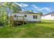 A backyard showcasing a house with a wooden deck and a lush green lawn at 5175 Grand Canyon Rd, Concord, NC 28027