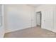 Neutral carpeted bedroom with two doors, and a window allowing natural light at 5175 Grand Canyon Rd, Concord, NC 28027