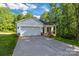 Beautiful home exterior with an attached garage and a spacious driveway surrounded by lush trees at 5175 Grand Canyon Rd, Concord, NC 28027