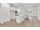 Open-concept kitchen with stainless steel appliances, a center island, and bright white cabinetry at 5175 Grand Canyon Rd, Concord, NC 28027