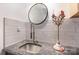 Close up of granite countertop with modern faucet and round mirror in updated bathroom at 6103 Warrior Ave, Fort Mill, SC 29707