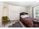 Charming bedroom featuring a wooden bed frame, decorative wall panels, and a comfortable seating area by the window at 6103 Warrior Ave, Fort Mill, SC 29707