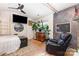 Modern bedroom with a slate accent wall, decorative plants, and sleek decor, with TV and comfortable seating at 6103 Warrior Ave, Fort Mill, SC 29707