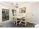 Elegant dining room with dark floors and ornate chairs, chandelier, and sliding glass doors to outside living space at 6103 Warrior Ave, Fort Mill, SC 29707