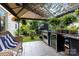Charming covered patio with outdoor kitchen, sitting area, grill, and lush greenery at 6103 Warrior Ave, Fort Mill, SC 29707