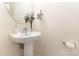 Bright powder room features a pedestal sink with decorative accents, a round mirror, and modern fixtures at 6103 Warrior Ave, Fort Mill, SC 29707
