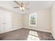 Well-lit bedroom with neutral walls, plush carpet, a ceiling fan, and a bright window at 613 Gold Hill Dr, Salisbury, NC 28146