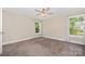 Cozy bedroom featuring plush carpet, a ceiling fan, and bright natural light from the two large windows at 613 Gold Hill Dr, Salisbury, NC 28146