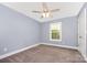 Simple bedroom with grey walls, neutral carpet, a ceiling fan, and a large window at 613 Gold Hill Dr, Salisbury, NC 28146