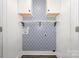 Practical laundry room offering upper cabinets, ample shelving and stylish patterned wallpaper at 613 Gold Hill Dr, Salisbury, NC 28146