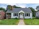 Charming white home featuring a brick chimney, black shutters, and a covered porch at 626 1St Se Ave, Hickory, NC 28602
