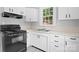 Traditional kitchen with white cabinets, laminate countertops, and black appliances at 626 1St Se Ave, Hickory, NC 28602