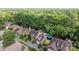 Aerial view of a brick home with a swimming pool nestled among mature trees and landscaped grounds at 7213 Baniff Cir, Charlotte, NC 28277
