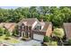 Brick home showcasing classic architecture, a well-manicured lawn, mature trees and two car garage at 7213 Baniff Cir, Charlotte, NC 28277