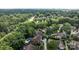 An aerial view shows a lush, green neighborhood with mature trees and well-maintained homes, some featuring private pools at 7213 Baniff Cir, Charlotte, NC 28277
